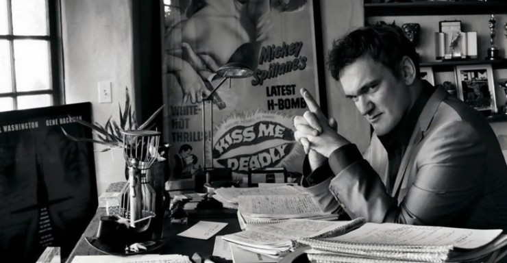 Quentin Tarantino looks into the camera while writing a screenplay at his desk, presumably for his new movie. 