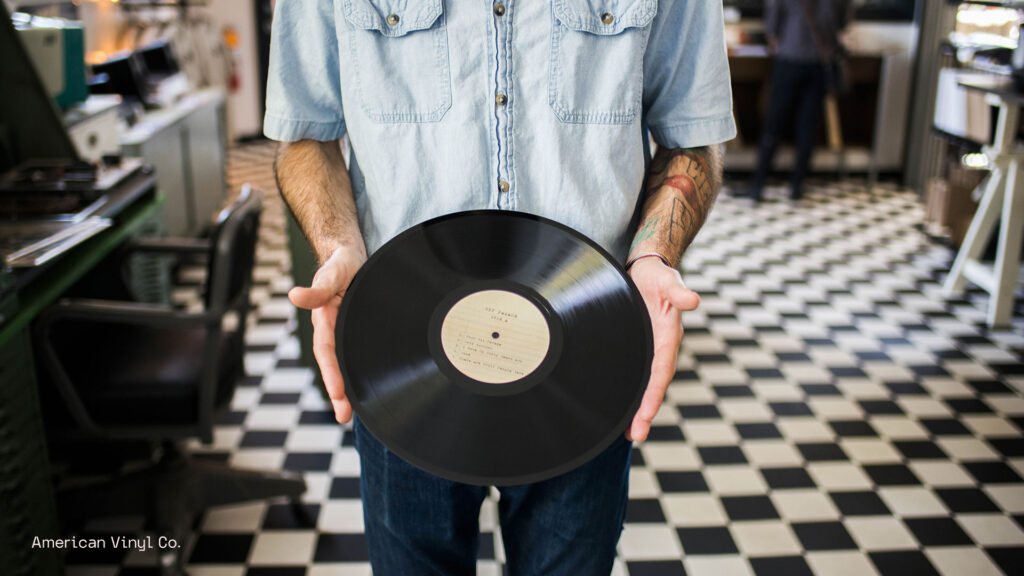 Image of man holding record in a record shop